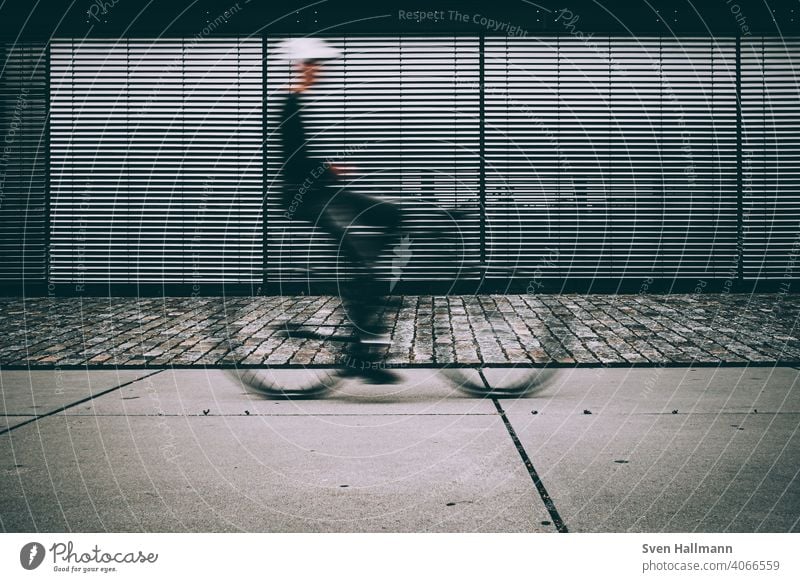 Blurred cyclist in front of closed blinds Bicycle minimalism Silhouette Abstract Bremen Long exposure lines urban Cycling Bikers defocused tutorial cyclists