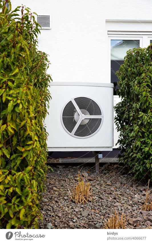 Air source heat pump in the front garden of a house. Modern, environmentally friendly heating technology. Air source heat pump Heating Air-to-water heat pump