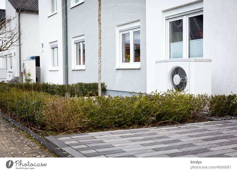 Air source heat pump in the front garden of a terraced house. Modern, environmentally friendly heating technology. Air source heat pump Heating