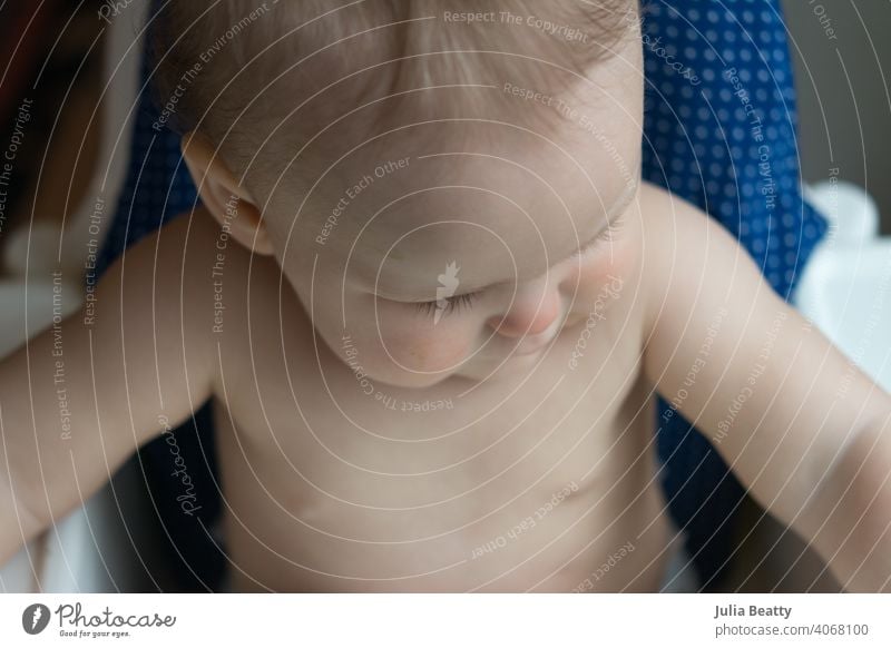 Looking down at young baby seated in high chair waiting for food infant child 6-12 months old finger food bird's eye view pincer grasp raking homemade weaning