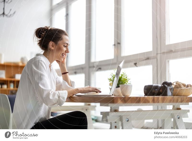 Creative young woman working on laptop in her studio millennials student hipster indoors loft window natural girl adult one attractive successful people