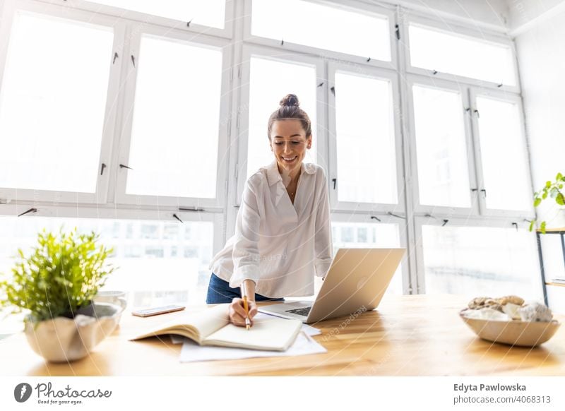 Young woman working in creative start-up company millennials student hipster indoors loft window natural girl adult one attractive successful people confident