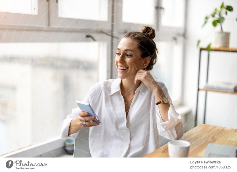 Shot of a young businesswoman using smartphone in an office millennials student hipster indoors loft window natural girl adult attractive successful people