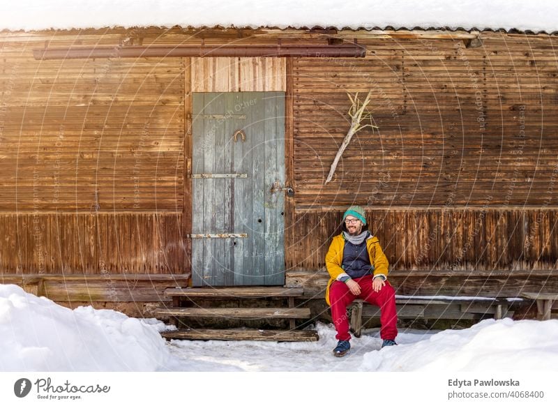 Man sitting in front of a traditional wooden house Wooden house healthy lifestyle Ecological Vintage Country house country Wanderlust Log Cottage forests