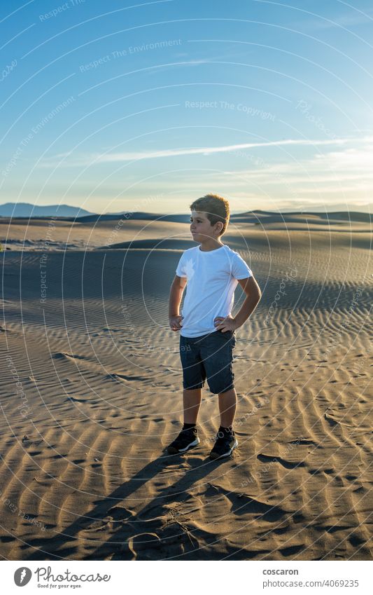 Little boy looking away in the desert arid beach casual caucasian child clear dry dune ecology enjoy enjoyment environment fun happy holidays hot kid landscape