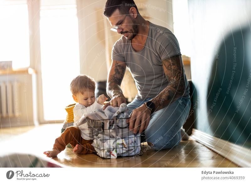 Father and son doing laundry together single parent single dad fathers day fatherhood stay at home dad paternity leave modern manhood family child house girl