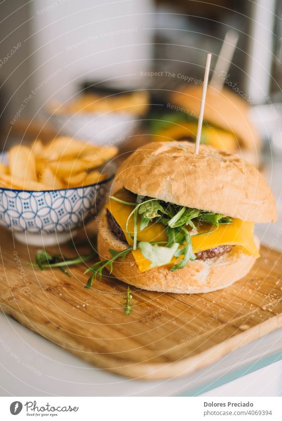 gourmet burger with cheddar cheese, tomato, mayonnaise, arugula and served with deluxe fries Cheeseburger Fast food homemade tabletop Bacon Glittering