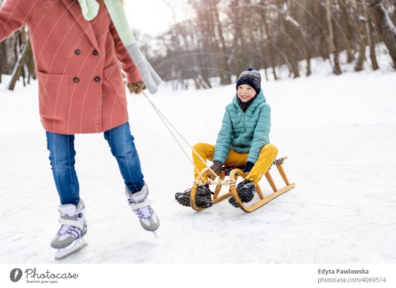 Mother and son having a great winter day outdoors playing in the snow mother daughter season together frozen cheerful fun kid people park holiday forest