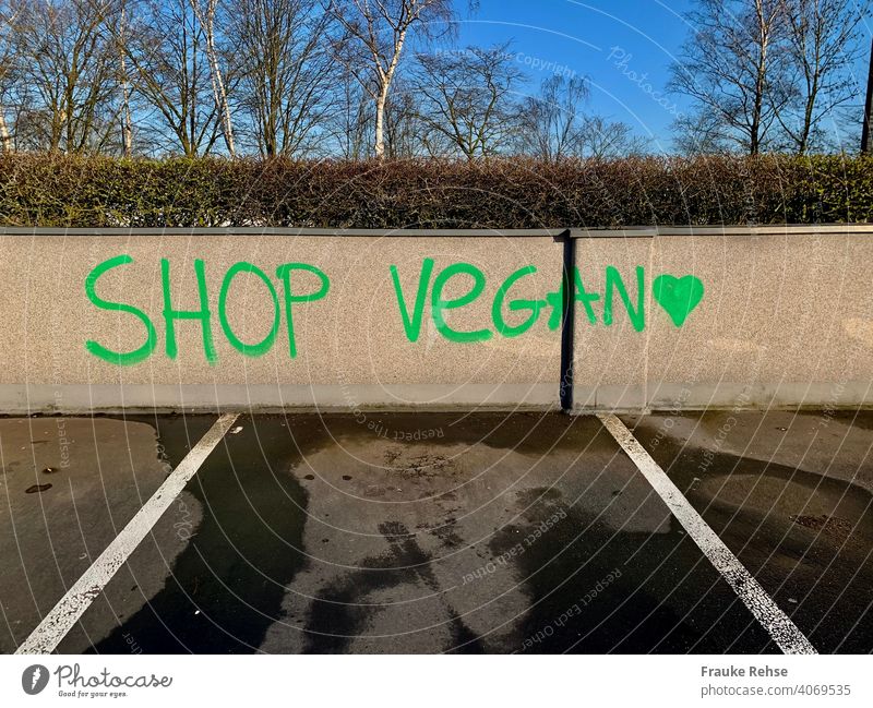 SHOP VEGAN - written in green letters on a wall in a parking lot vegan Vegan diet veganism vegan shopping Verdant purchasing Parking lot invitation Heart Green