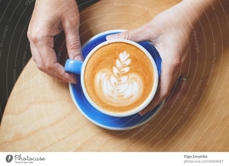 Woman's hand holding a coffee with latte art. woman cappuccino cup mug background person vintage white cafe drink espresso hot top beverage breakfast caffeine