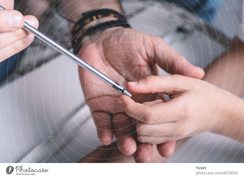 Hands of a man and his child are holding a screwdriver. Furniture assembling. Housework. Top view. hands caucasian furniture housework top view father kid