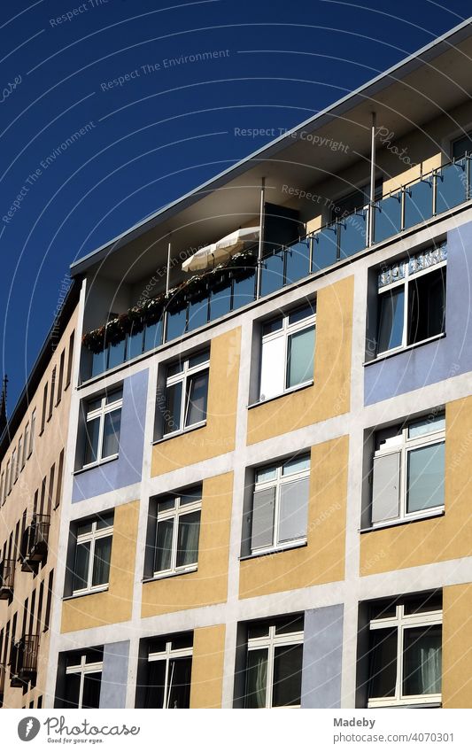 Restored two-tone façade in beige and blue with covered balcony in summer sunshine in the city centre of Frankfurt am Main in the German state of Hesse