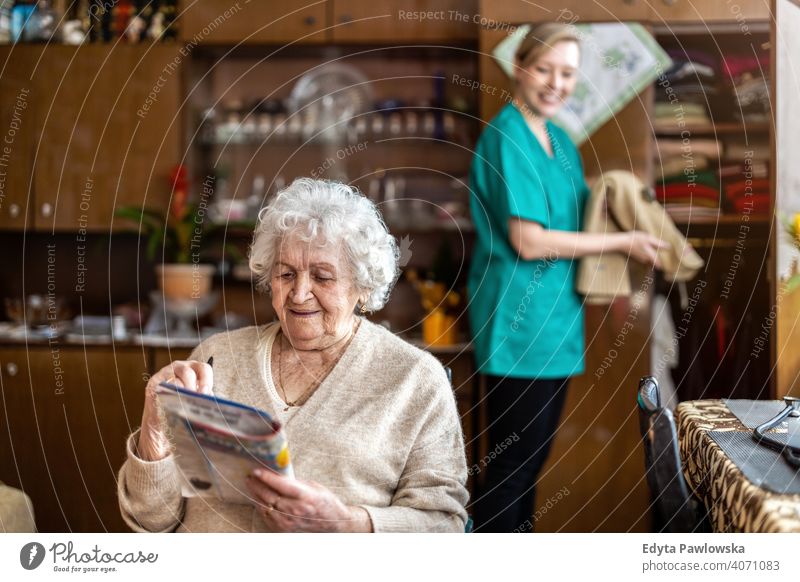 Female nurse taking care of a senior woman at home real people candid genuine mature female Caucasian elderly house old aging domestic life grandmother