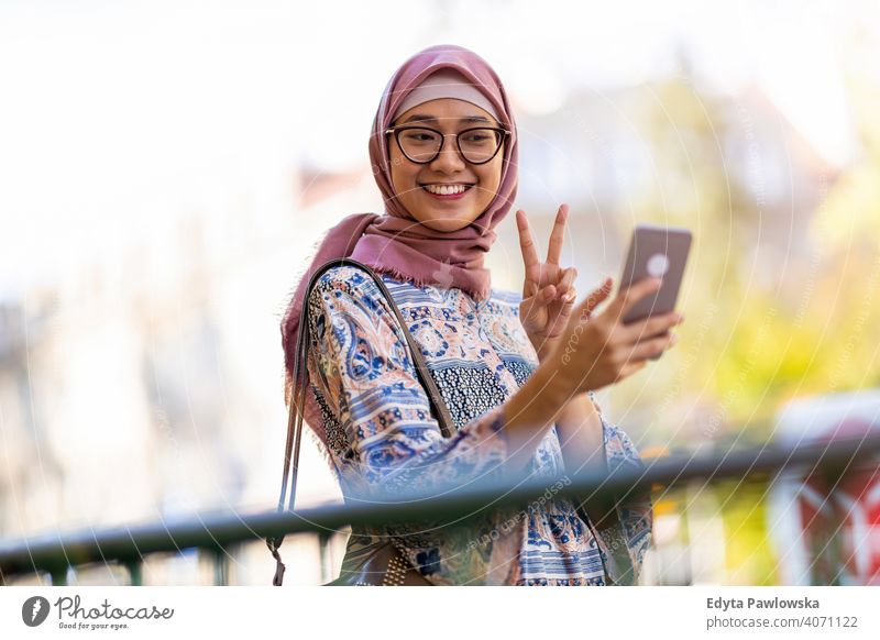 Young woman wearing a hijab taking a selfie headscarf muslim islam arabic summer girl people young adult female lifestyle active outdoors millennial outside