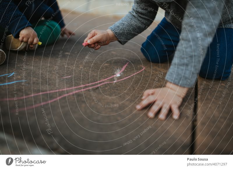 Child drawing with colored chalk on the floor Chalk Chalk drawing Creativity Drawing Infancy Street Playing Joy Children's game Art Leisure and hobbies