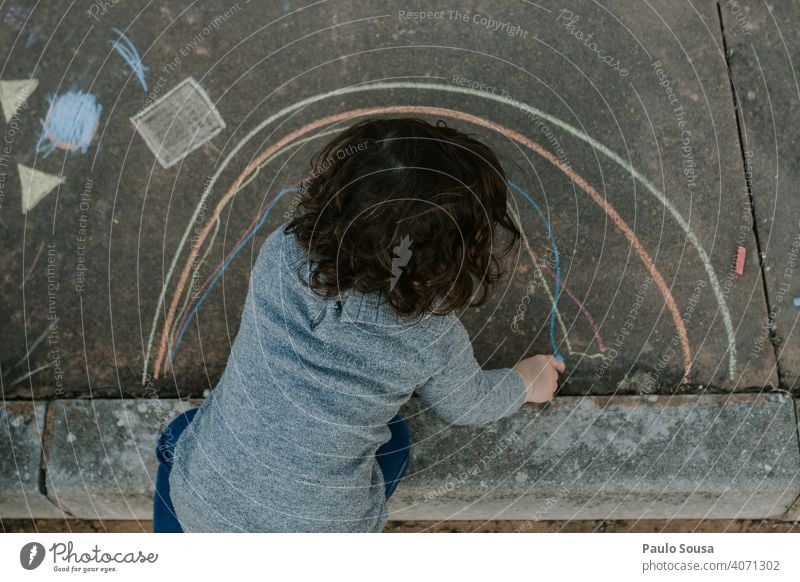 Child drawing with colored chalk on the floor Chalk Chalk drawing childhood Painting and drawing (object) Street Playing Drawing Infancy Asphalt Street painting