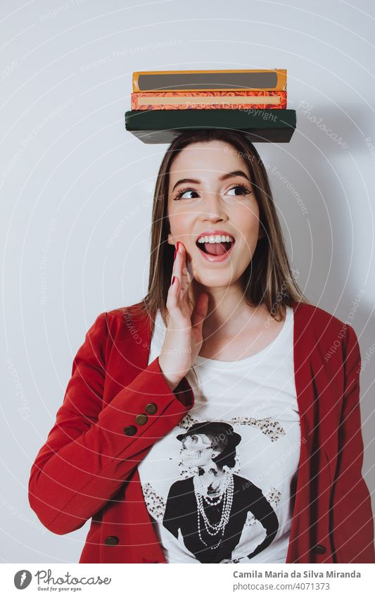 excited young woman holding books on her head adult background beautiful casual cheerful college confident education expression face female fun girl hair hand