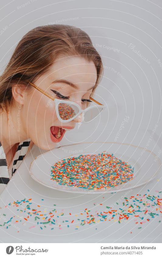 Fun photo of woman looking at plate with colorful sweet confetti. anniversary anxiety background beautiful birthday candy celebration copyspace creative