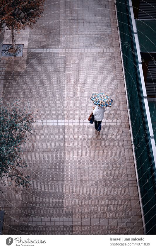 woman on the street with an umbrella in rainy days people person raining water human pedestrian city urban bilbao spain walking lifestyle weather winter spring