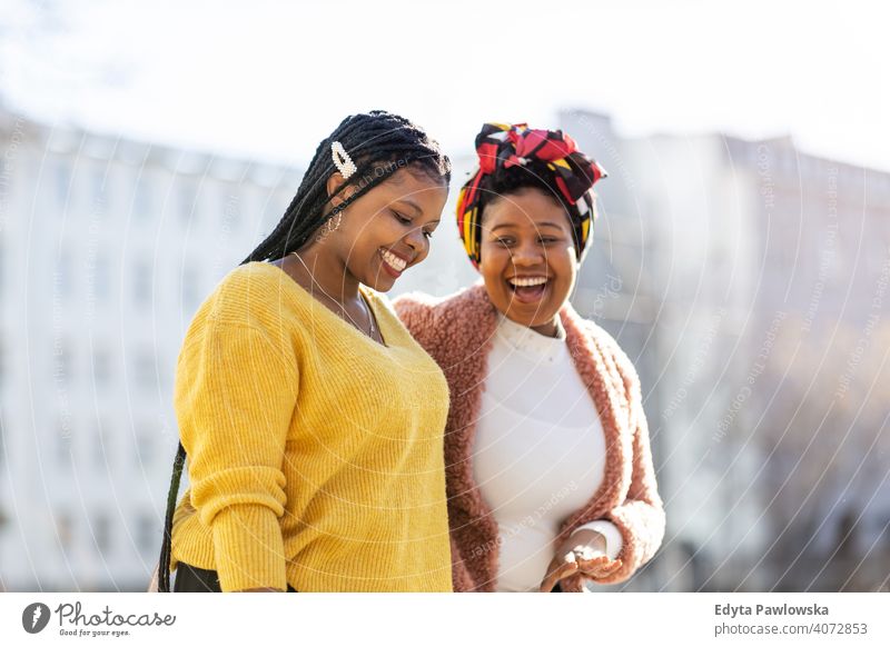 Beautiful happy girlfriends talking and smiling in city diversity diverse people love outdoors day positivity confident carefree woman young adult casual