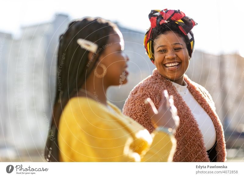 Beautiful happy girlfriends talking and smiling in city diversity diverse people love outdoors day positivity confident carefree woman young adult casual