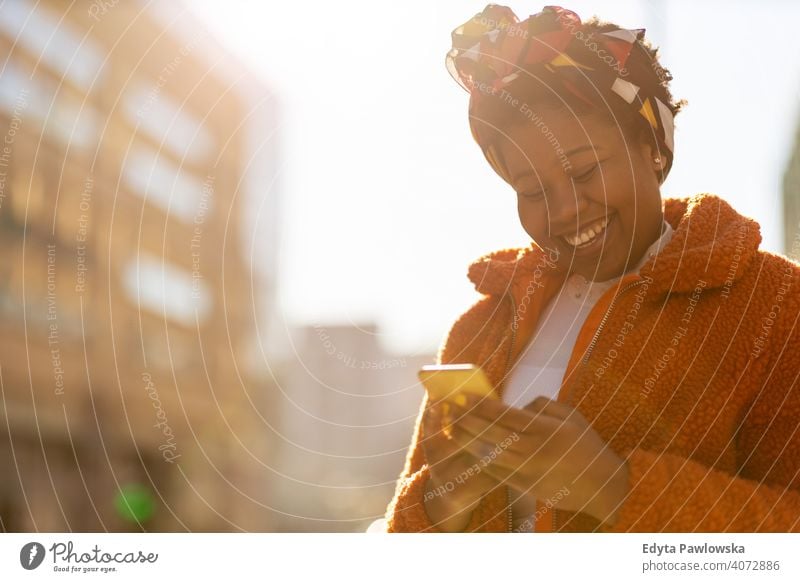 Young woman with smartphone in an urban city area one person alone outdoors day positivity confident carefree people young adult casual beautiful attractive