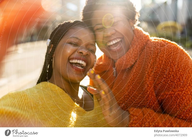 Two beautiful Afro american women having fun together in the city diversity diverse people love outdoors day positivity confident carefree woman young adult