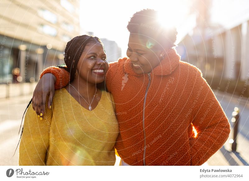 Two beautiful Afro american women in an urban city area diversity diverse people love outdoors day positivity confident carefree woman young adult casual