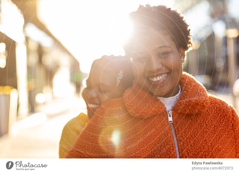 Two beautiful Afro american women in an urban city area diversity diverse people love outdoors day positivity confident carefree woman young adult casual