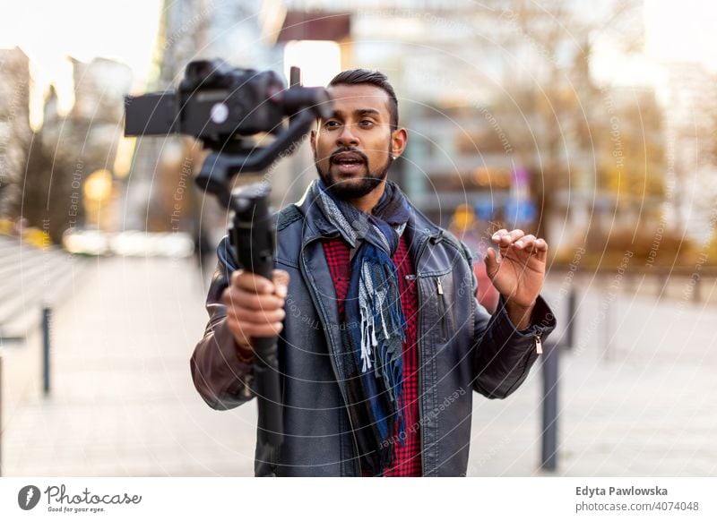 Man filming a vlog with camera in the city video blogger vlogger journalist influencer photographer technology travel tourist explorer freelancer reportage