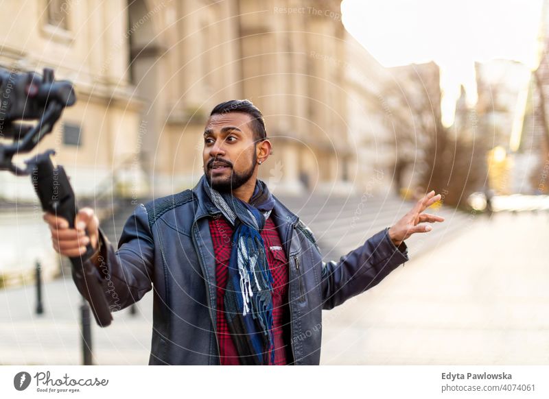 Man filming a vlog with camera in the city video blogger vlogger journalist influencer photographer technology travel tourist explorer freelancer reportage