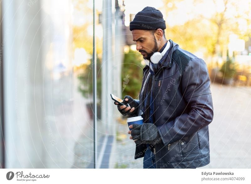 Young man window shopping on city street Sinhalese asian Indian bearded outside urban standing outdoors Warsaw one casual lifestyle guy attractive handsome