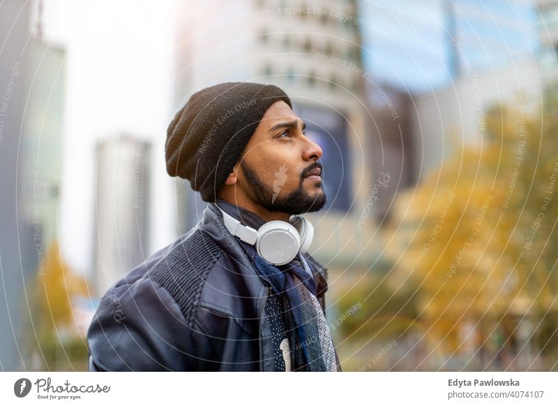 Portrait of a stylish young man standing in a city street Sinhalese asian Indian bearded outside urban outdoors Warsaw one casual lifestyle guy attractive