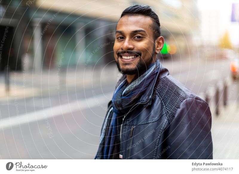 Portrait of a beautiful smiling man Indian ethnicity looking at the camera Sinhalese asian bearded outside street urban standing outdoors Warsaw one casual