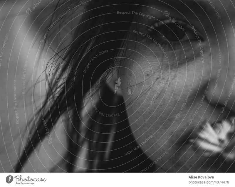 last teardrop girl Tears straight face portrait close up black and white Black and white portrait getting flowers holding flower Face of a woman