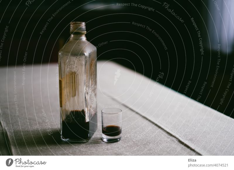 liquor bottle filled with alcohol stands next to liquor glass on a table booze Alcoholic drinks Table bottle of booze Schnaps glass Bottle Drinking Alcoholism