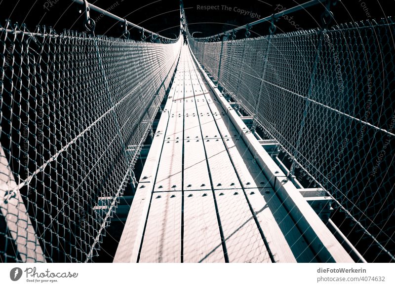 Suspension bridge with backlight Architecture Bridge Germany Dark Europe Vanishing lines vulture layer Hunsrück West Germany Gray Black Exterior shot