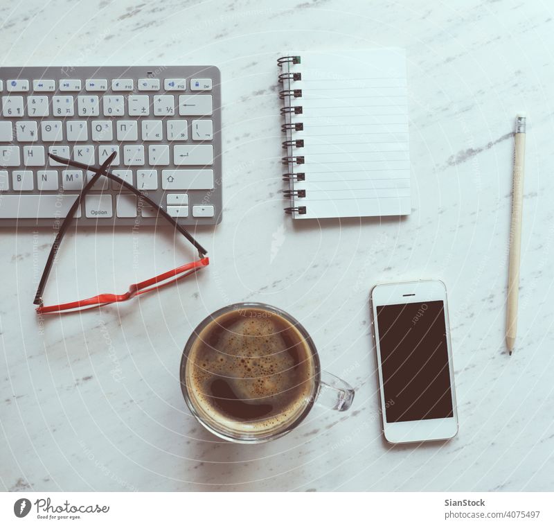 Workplace with notebook, coffee, smartphone, glasses and keyboard. laptop desk view table office computer cup desktop white above work business background paper