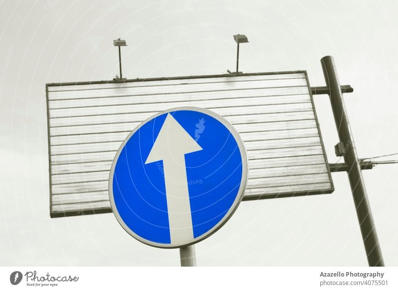 Blue traffic sign and an empty metal advertisement board. city urban ahead alert arrow background blue blue sign caution circle concept construction direction