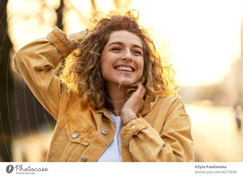 Portrait of young woman with curly hair in the city natural sunlight urban hipster stylish positive sunny cool afro joy healthy freedom sunset enjoyment summer