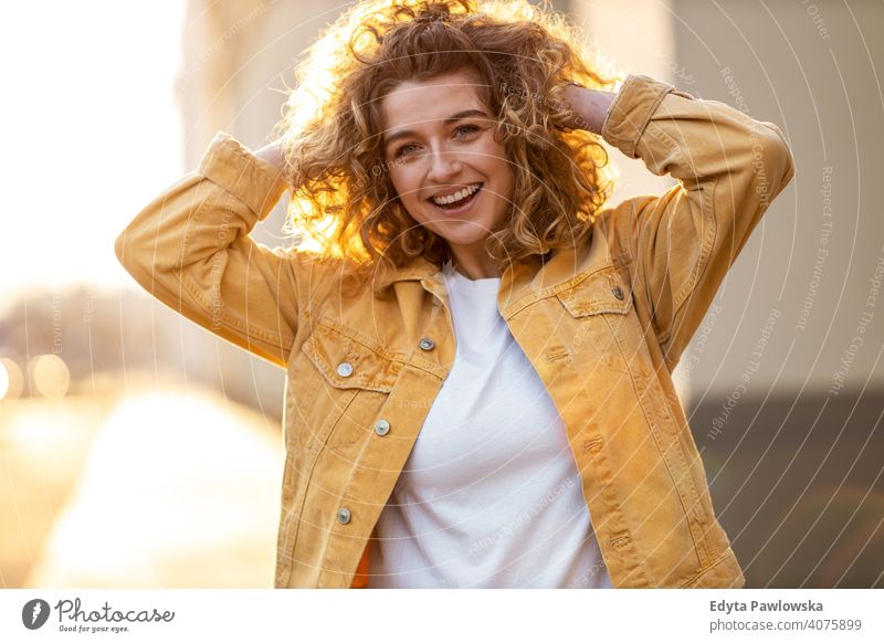 Portrait of young woman with curly hair in the city natural sunlight urban hipster stylish positive sunny cool afro joy healthy freedom sunset enjoyment summer