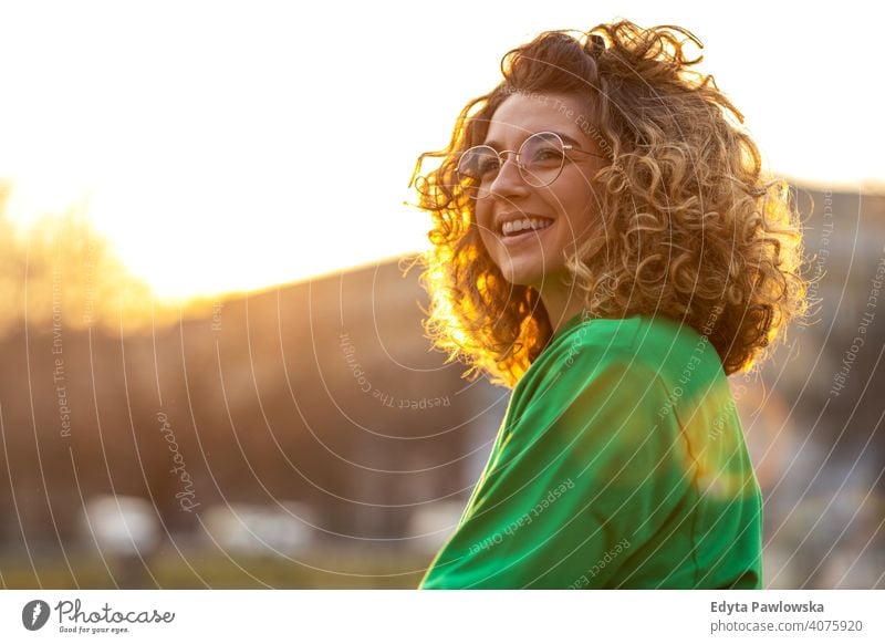 Portrait of a young woman with curly hair in the city naturally Sunlight Curly urban City Hipster stylish Positive sunny Cool Afro Joy Healthy Freedom Sunset