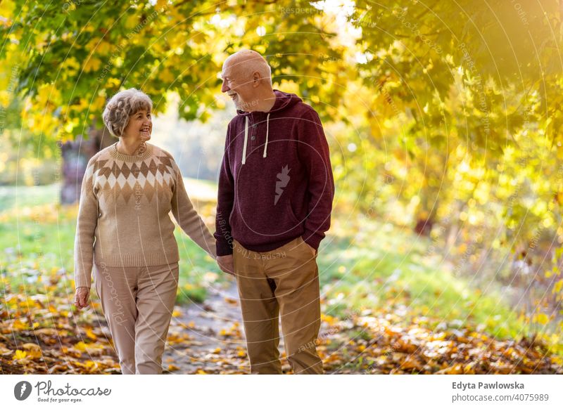 Happy senior couple enjoying a day outdoors in autumn love real people retired pensioner retirement aged grandmother grandparent grandfather two togetherness