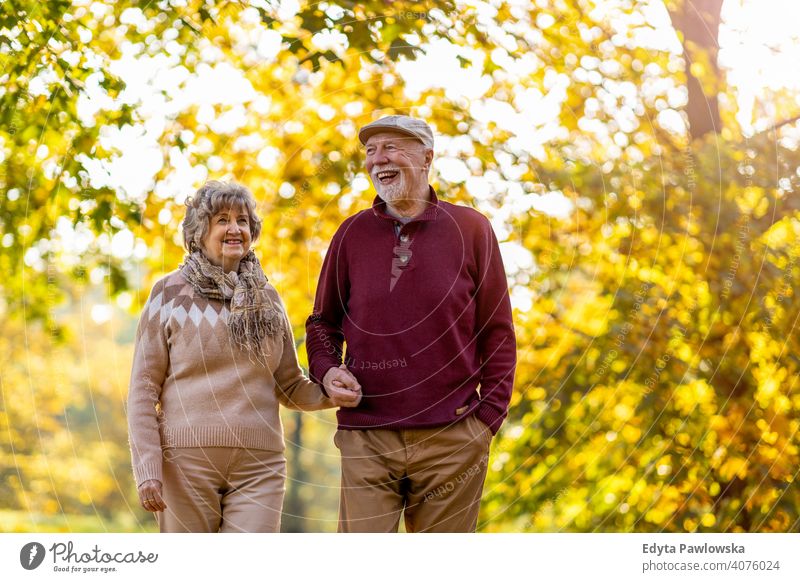 Happy senior couple enjoying a day outdoors in autumn love real people retired pensioner retirement aged grandmother grandparent grandfather two togetherness