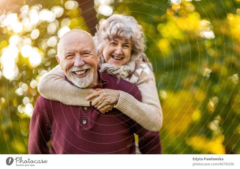 Happy senior couple enjoying a day outdoors in autumn love real people retired pensioner retirement aged grandmother grandparent grandfather two togetherness