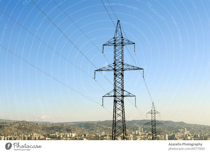 Electricity pylons with a cityscape. blue business cable civilization current danger design distribution ecology electric electrical electricity energy