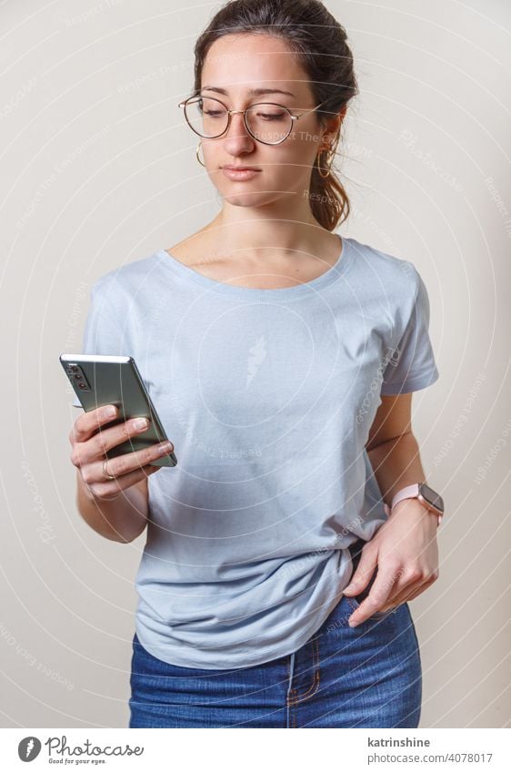 Young women using cell phone wear mockup t-shirt smart phone Lifestyle jeans glasses serious concentrated round neck casual mock up Person Portrait Human Female