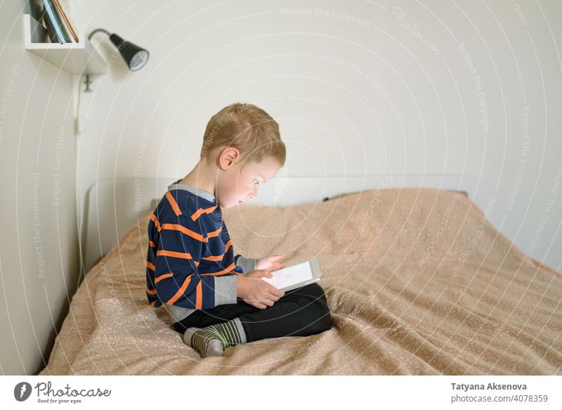 Boy using tablet on bed child boy internet technology learning modern home digital leisure education digital tablet communication childhood person indoor