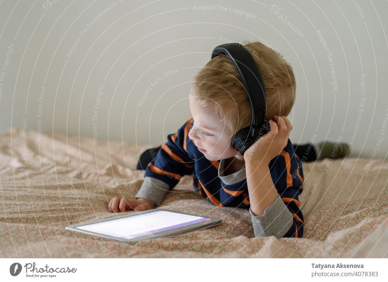 Boy using tablet on bed child boy internet technology learning modern home digital leisure education digital tablet communication childhood person indoor