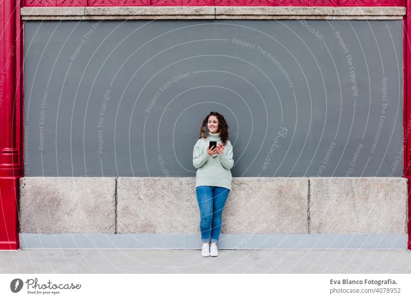 young caucasian woman using mobile phone outdoors in the city. Technology and lifestyle urban technology texting street cyberspace smart app text message happy